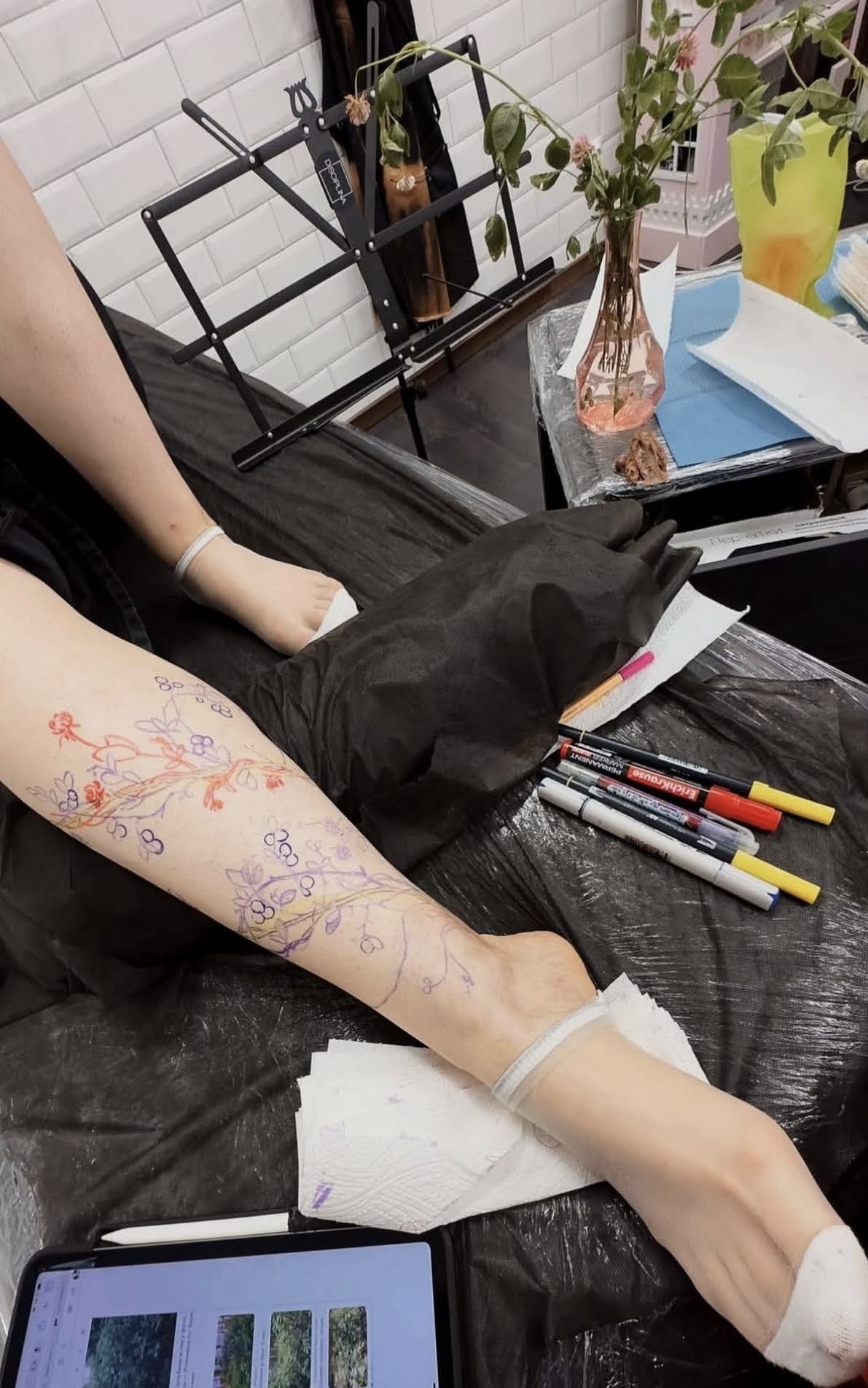 Wildflower sketch drawn directly on skin with pencils nearby